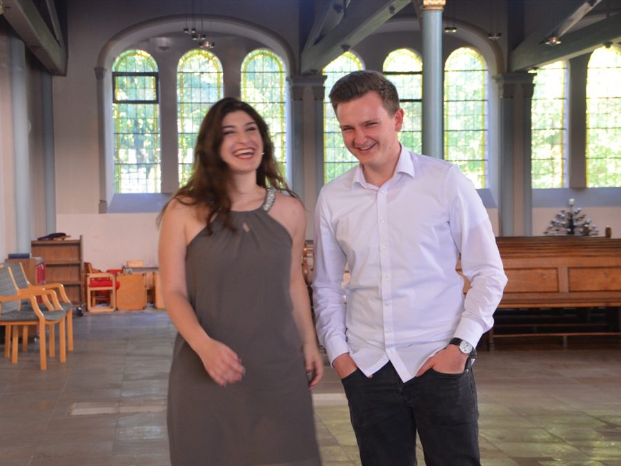 Dominik und Sophia lachen gemeinsam in einer hellen Kirche